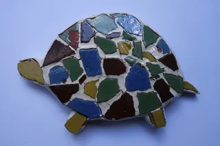 Handgetöpfert, mit mosaikartig eingelegten Bruchstücken orginaler Ziegel der (alten) Ludwigs-Kirche, München. Diese wurden bei der Dacherneuerung einfach heruntergeworfen, Größe ca. 23 cm.