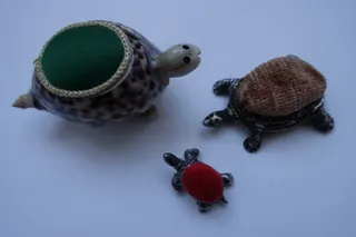 Nadelkissen, Basis sind Kaurimuscheln bzw. kleine Schildkröten aus Silber (gestempelt).