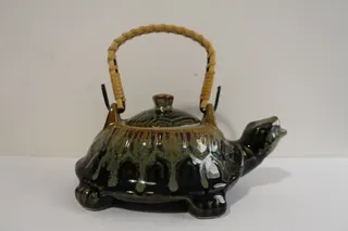 Kleine Teekanne (Asien), getöpfert und glasiert, der Griff mit Bast umwickelt, ca. 16 cm.