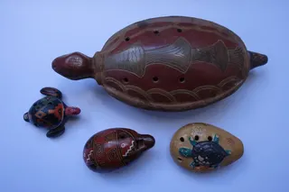Okarinas (Gefäßflöten) aus Nord- und Südamerika, aus Ton gebrannt und bemalt, überwiegend mit 6 Löchern (und 2 Daumenlöchern an der Unterseite), sie werden am Band um den Hals getragen, Größe 7 - 23 cm. Okarinas sind heute meist ein Souvenir, wurden aber schon von den Mayas, Inkas oder Azteken gespielt.