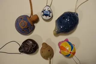 Leider falsche Bildzuordnung! Okarinas (Gefäßflöten) aus Südamerika, u.a. aus Ecuador, Peru und Mexiko. Aus Ton, gebrannt und zum Teil bemalt, überwiegend mit 6 Löchern (davon 2 Daumenlöcher an der Unterseite), am Band um den Hals zu tragen. Okarinas sind heute meist ein Souvenir, wurden aber schon von Mayas, Inkas oder Azteken gespielt.