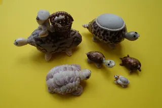 Mit Hilfe diverser Muscheln gestaltete Souveniers aus südeuropäischen Länder, z.B. als Mitbringsel für Kinder. Das Steckkissen kann aber auch als Gebrauchsgegenstand dienen.