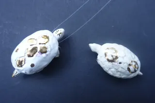 Handgetöpfert Unikate von einem Freund, mit echter Goldglasur (u.a. Friedenszeichen), beide Objekte sind als Schmuckanhänger tragbar, sign., Größe je ca. 5cm.