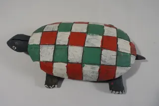 Das Objekt stammt aus der Sammlung Hölty, ist aus einem Stück geschnitzt und handbemalt, Größe 28 cm. Die Farben erinnern ein wenig an die italienische Trikolore.