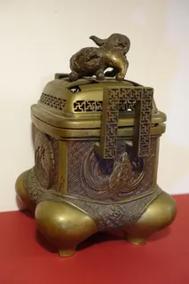 Weihrauch-Brenner (innen mit Restspuren) aus Japan, Messing, unter den Motiven finden sich Minogame und Kranich, aber auch uralte Hakenkreuzzeichen und ein Drache (auf dem Deckel), um 1900, im Boden sign., Grundfläche 14 x 14 cm, Höhe 20 cm.